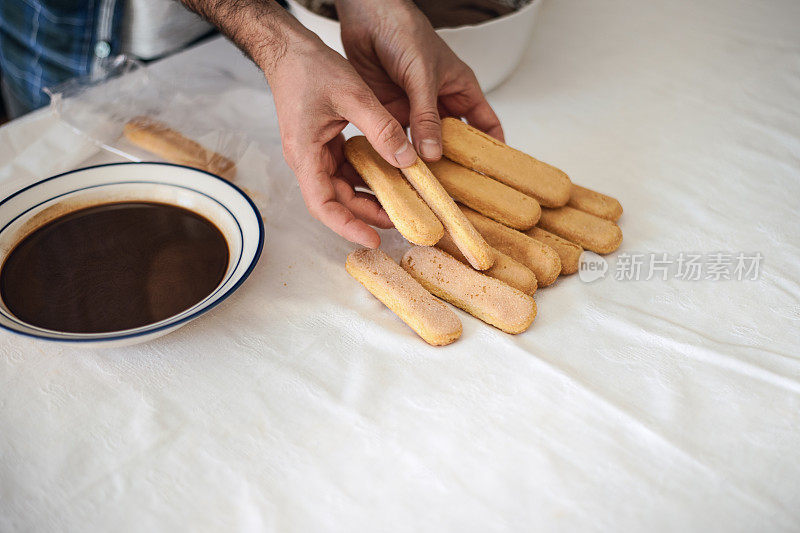 检疫烹饪:一名男子用电动搅拌器、巧克力、饼干和咖啡煮提拉米苏