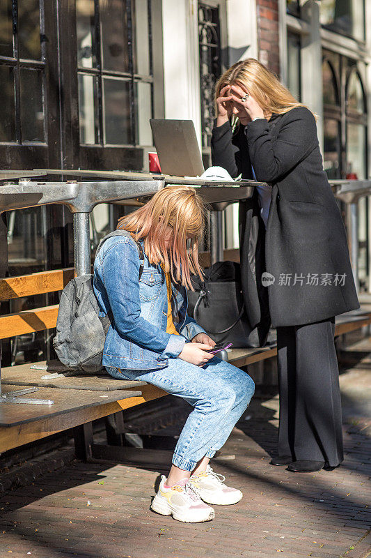 年轻的女学生戴着口罩和她的职业母亲