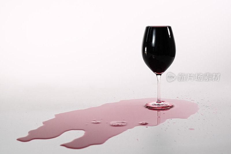 盛满红酒的杯子，倒在白桌子上，盛满红酒的杯子倒在桌子上，酒精，红汁，