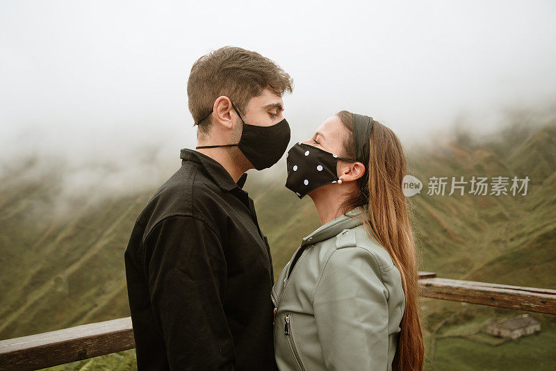 年轻夫妇戴着口罩，彼此站得很近