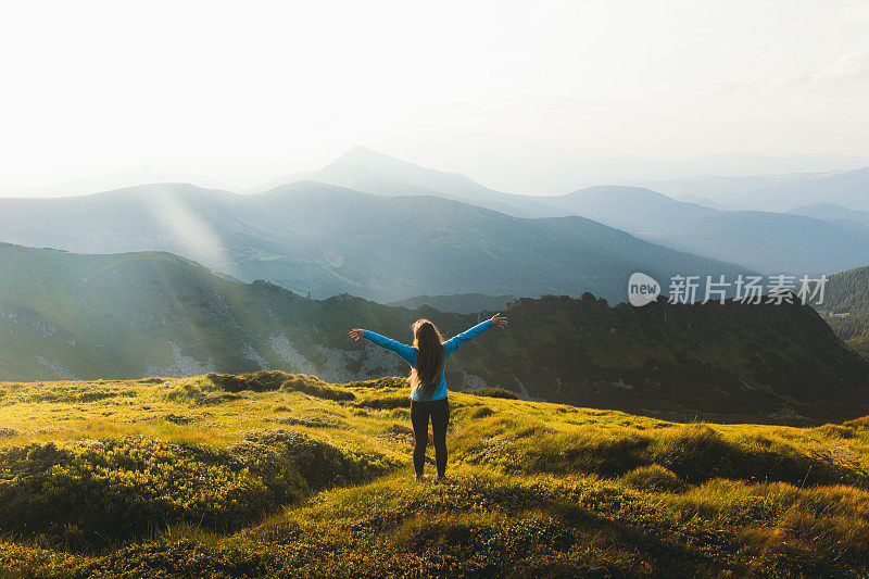 年轻的女旅行者有最好的时间在户外会见日落在山上