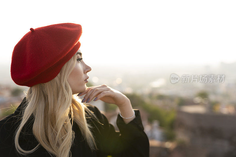一个戴着红色贝雷帽的女人的肖像。一个城市里的女人