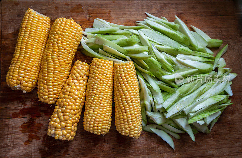 新鲜的玉米和蔬菜放在木板上
