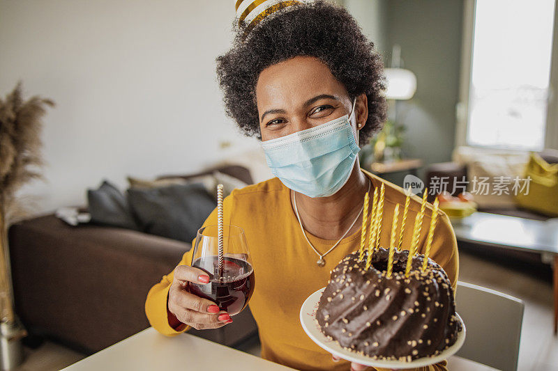 一名戴口罩的非洲妇女在疫情期间在家庆祝生日的肖像