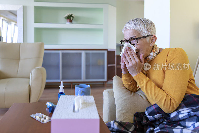 一名患季节性流感的妇女躺在床上用纸巾咳嗽。