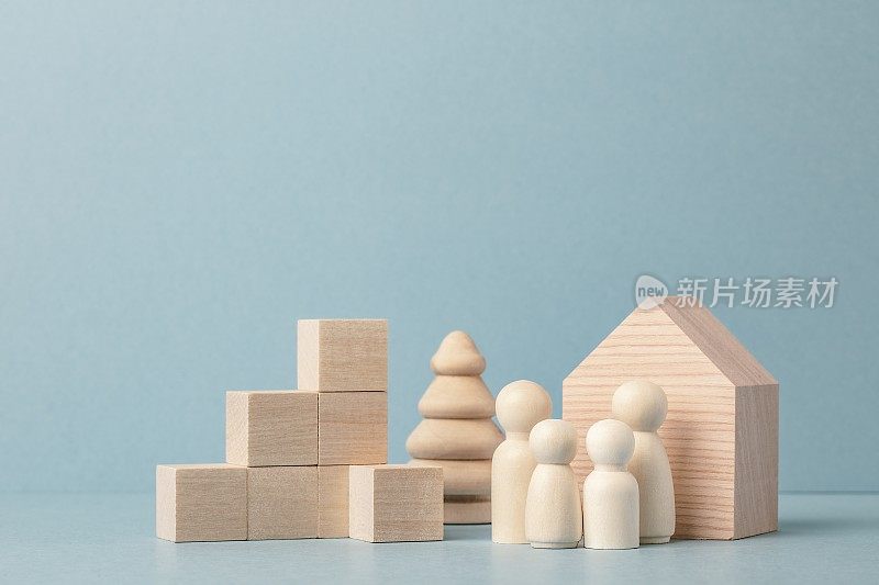 家庭发展与房地产概念。木屋与家庭，木立方体堆叠成递增图条。