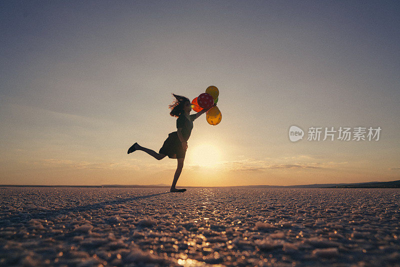 动机或希望的概念，跟随你的梦想和灵感，女孩气球在日落