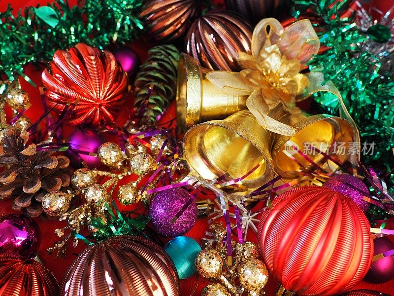 圣诞背景有圣诞装饰品、节日球、铃铛、蝴蝶结、冷杉锥、圣诞树雨。新年快乐，圣诞快乐。红色，棕色，条纹，绿色，金色，紫色，五颜六色的装饰
