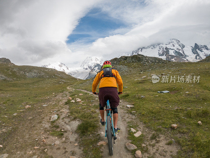 山地车的后视图在土路向冰川移动