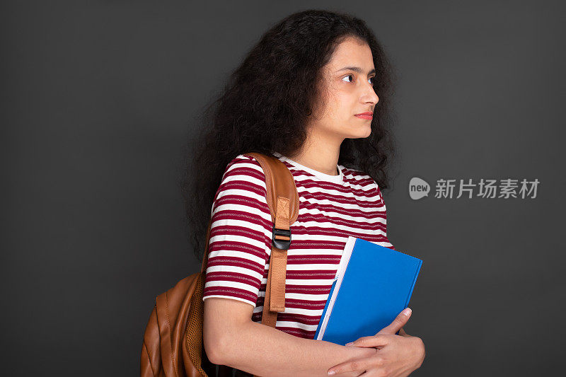 年轻女孩学生的肖像持有笔记本和有背包库存的图像