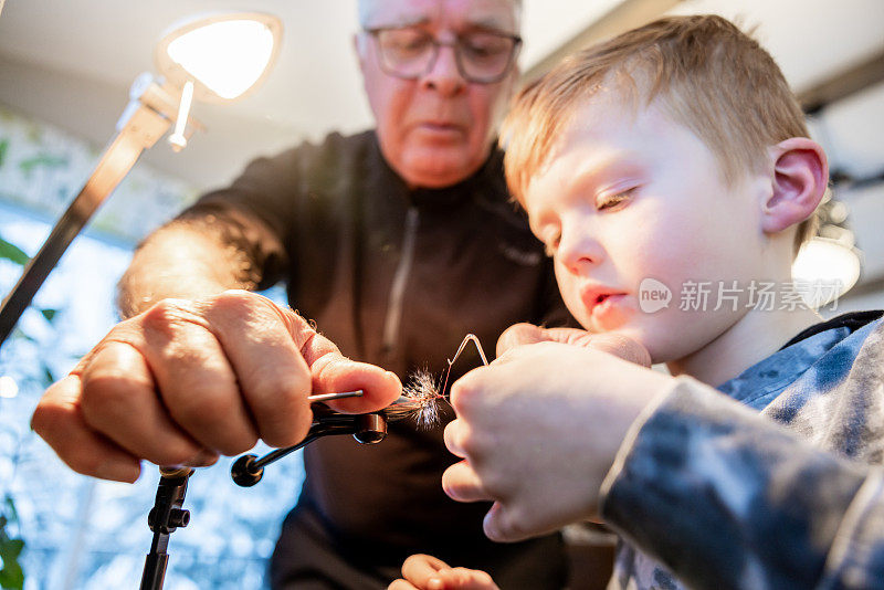 爷爷在家教他的孙子如何让钓鱼飞蝇