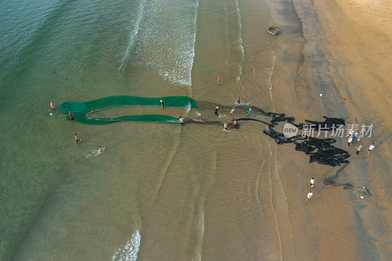 渔民在海滩边拉渔网