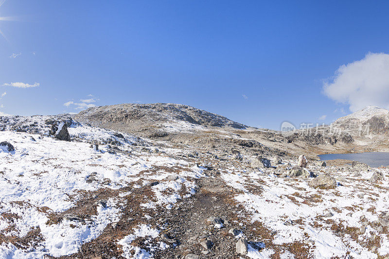 在挪威的高山上，沿着布满岩石的徒步路线，秋天的第一场雪