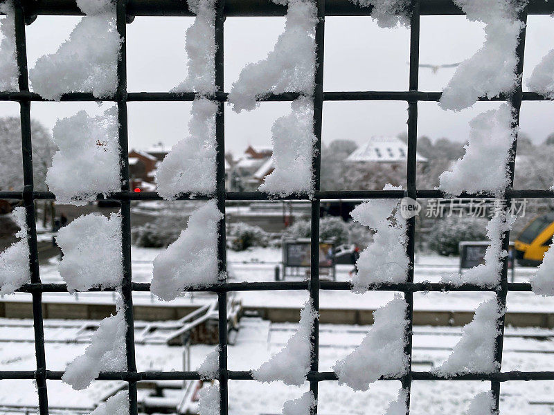 火车站被雪覆盖的金属栅栏