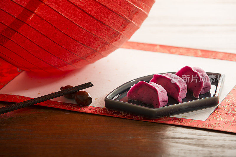 红色的饺子，展开的书法画卷，红色的纸灯笼，中国新年，节日气氛背景