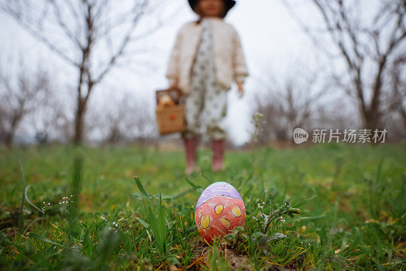 小女孩手里拿着五颜六色的复活节彩蛋。孩子们在春天公园里收集彩绘彩蛋。孩子们在户外寻找鸡蛋。