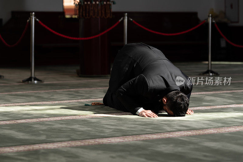 一名穆斯林男子跪在清真寺里向真主安拉进行传统的祈祷
