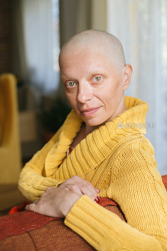 忧心忡忡的年轻癌症幸存者坐在沙发上