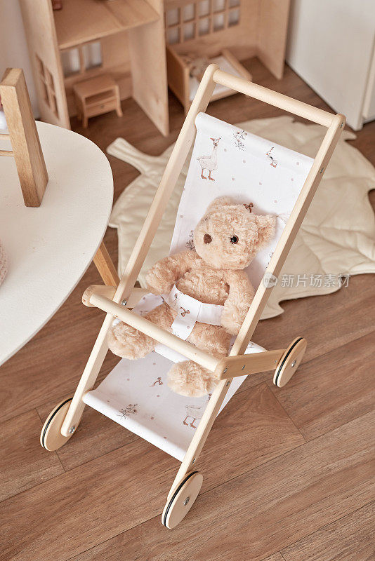 儿童益智木制玩具。育婴室装饰。斯堪的纳维亚风格的游戏室。木推车
