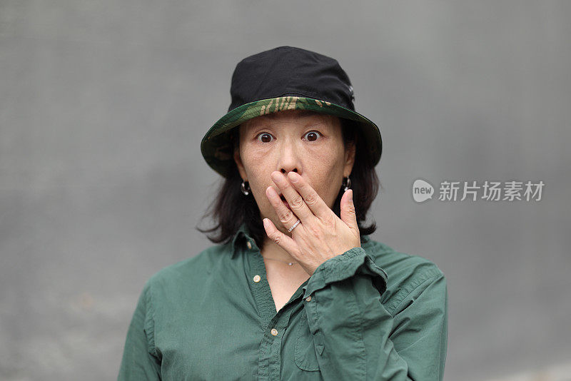一个戴着太阳帽的亚洲女人，脸上带着震惊的表情