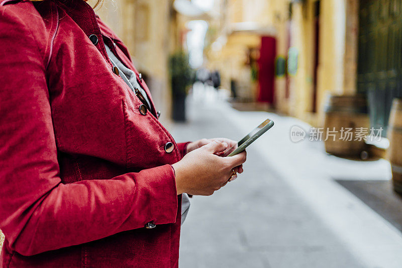 马耳他瓦莱塔，一名妇女在城市街道上使用手机