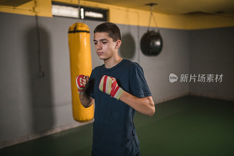 专注的年轻人在戴上拳击手套之前用一块布包裹他的手，这有助于减少拳击对手时的冲击，并有助于防止拳击受伤