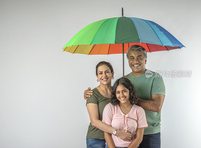 父母和女儿撑着白色背景的雨伞