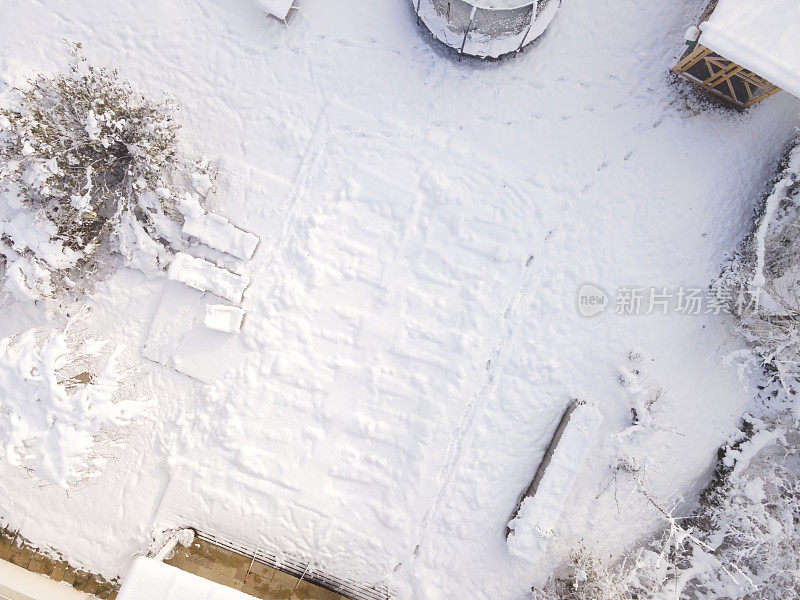 空中无人驾驶飞机飞过覆盖着防水油布的游泳池，冬天下雪，很冷