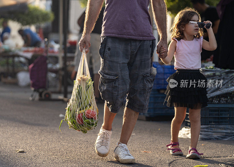 父亲和女儿在农贸市场购物的照片