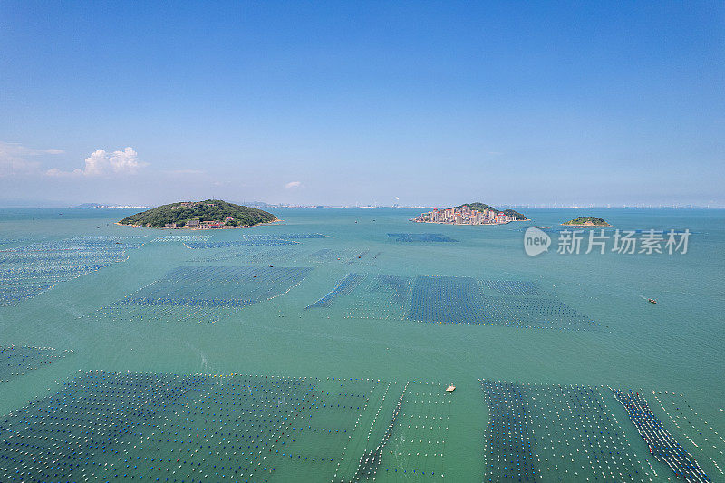 鸟瞰海中的小岛和海上漂浮的水产养殖场