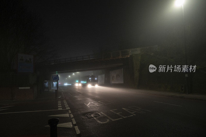 在一个雾蒙蒙的夜晚，一辆卡车从立交桥下驶过