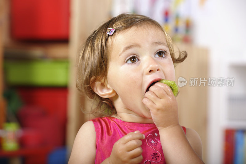 可爱的幼童在幼儿园吃健康的零食