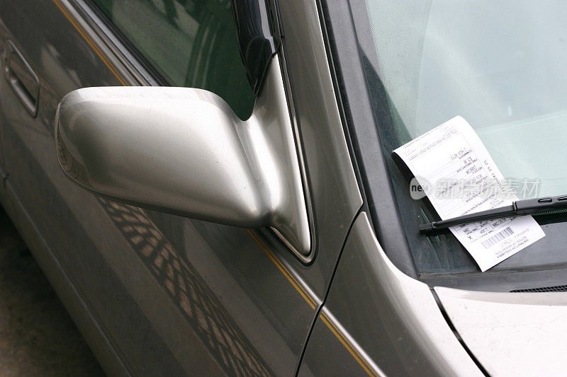 一辆车窗上贴着停车罚单的银色汽车