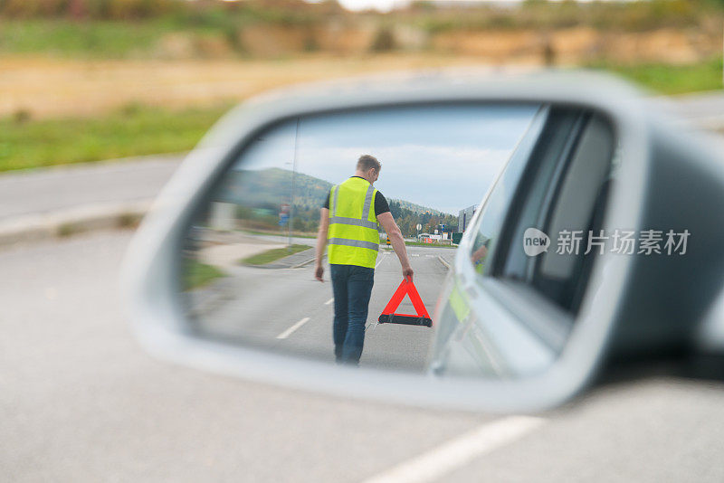 后视镜反射有人放置三角形警告标志