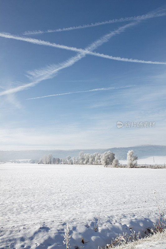 蓝色天空中雾气交错的冬季景观