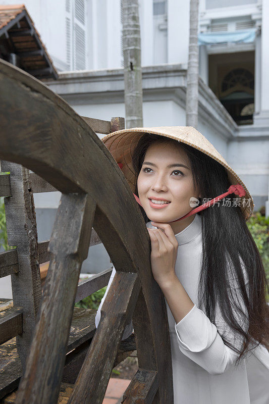 甜美的年轻越南女孩摆着传统澳黛