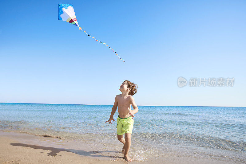 男孩在海滩上放风筝