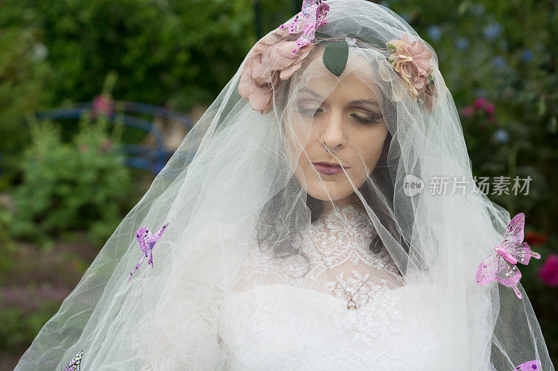 新娘头和肩膀都蒙着面纱，上面满是蝴蝶。