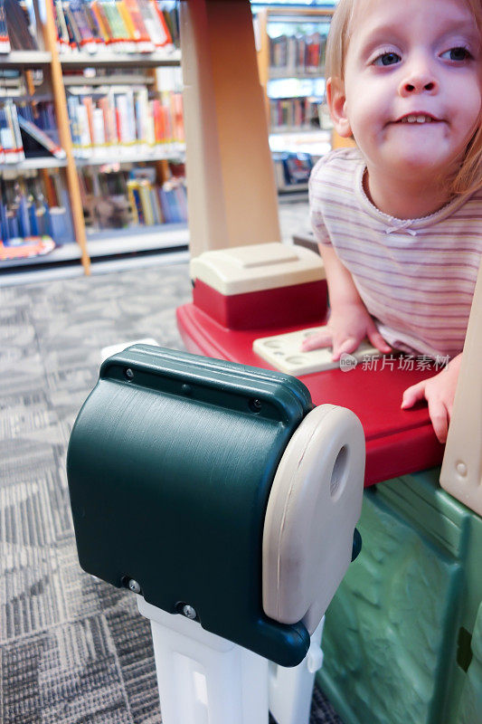 这是一封邮件:学龄前女孩在图书馆玩耍