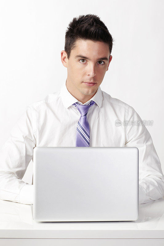 年轻的商人坐在笔记本电脑前工作