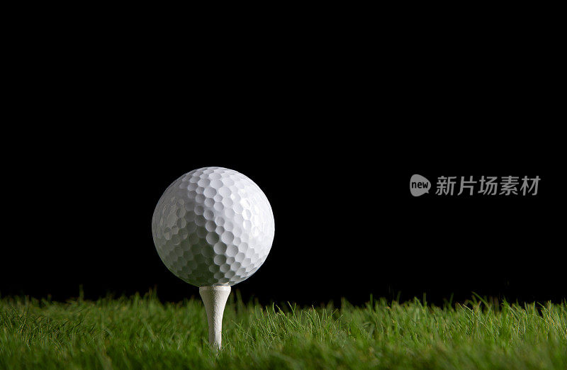 白色的高尔夫球和球座在绿色草地上