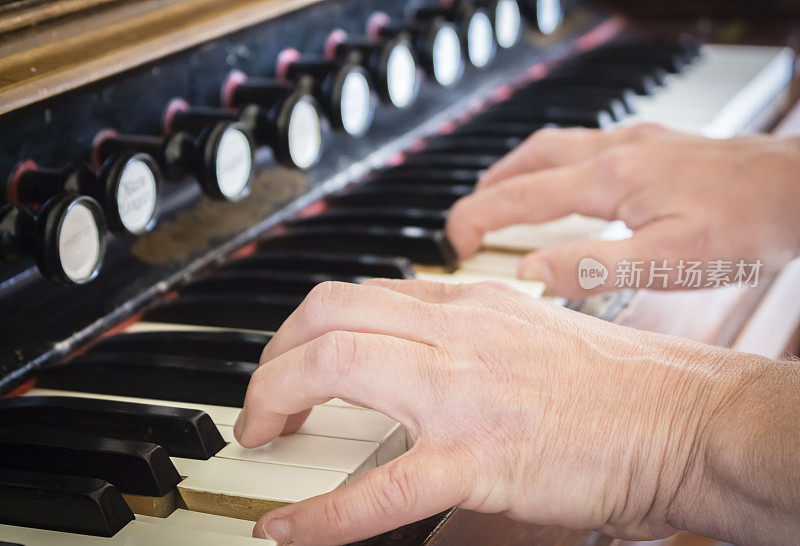 一对白种人的手在演奏风琴。