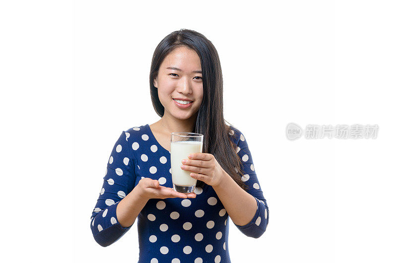 年轻的中国女子喝着一杯牛奶