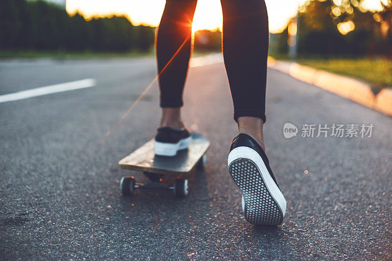 在日出街玩滑板的女人腿
