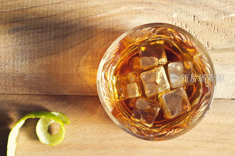 一杯威士忌加冰的木质背景，俯视图