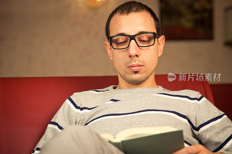 一个年轻人在全神贯注地读着一本书