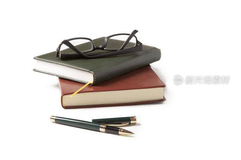 钢笔、笔记本和眼镜在白色的背景上