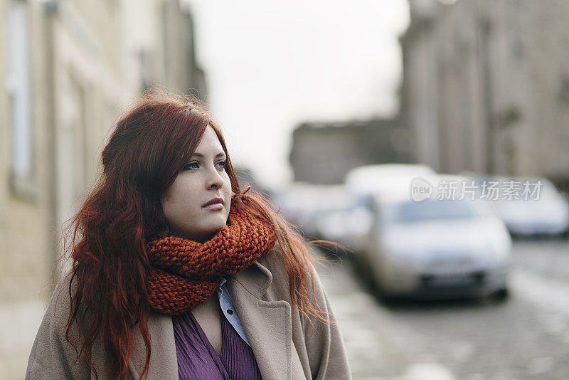 一个年轻女子穿着冬装走在镇上