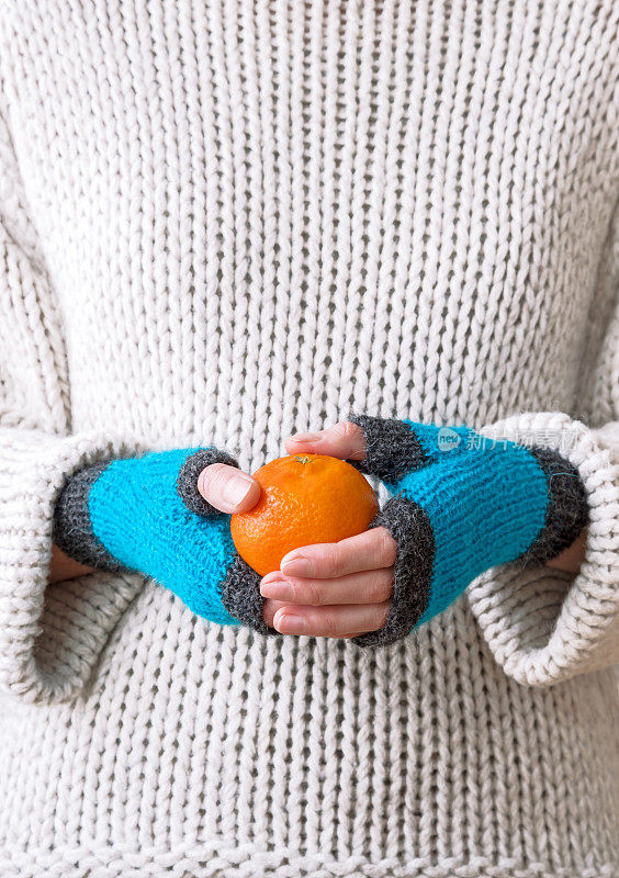 女人手里拿着一个橘子