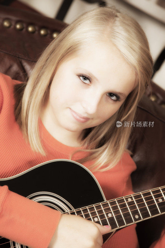 音乐:十几岁的女孩在家里弹吉他。